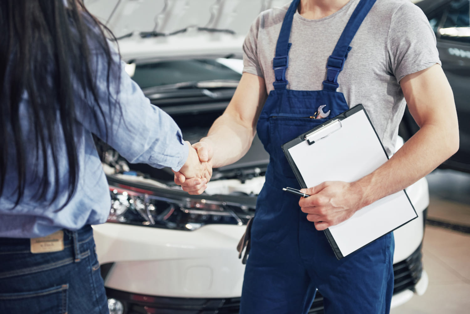 mari-mecanicien-automobile-femme-cliente-concluent-accord-reparation-voiture